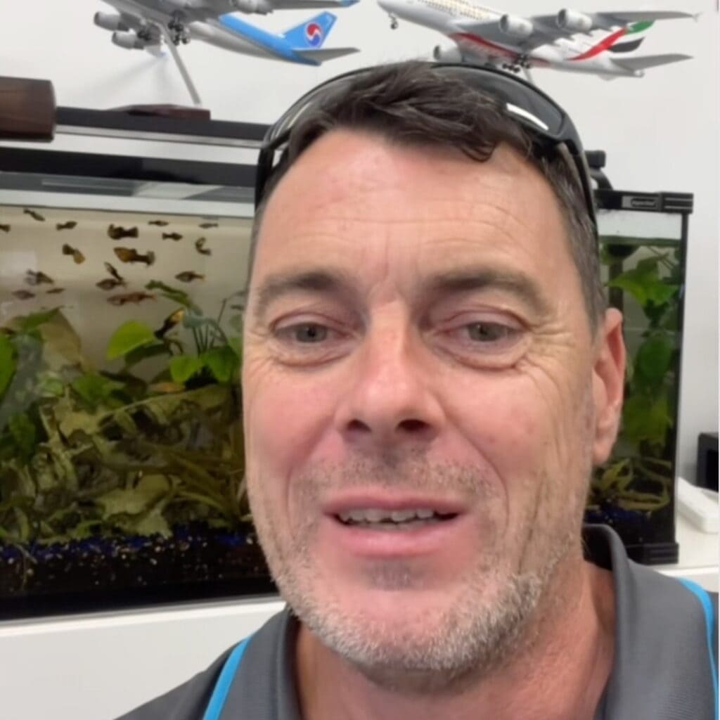 Professional aquarium maintenance service in brisbane checking fish tank health to prevent cloudy aquarium water.